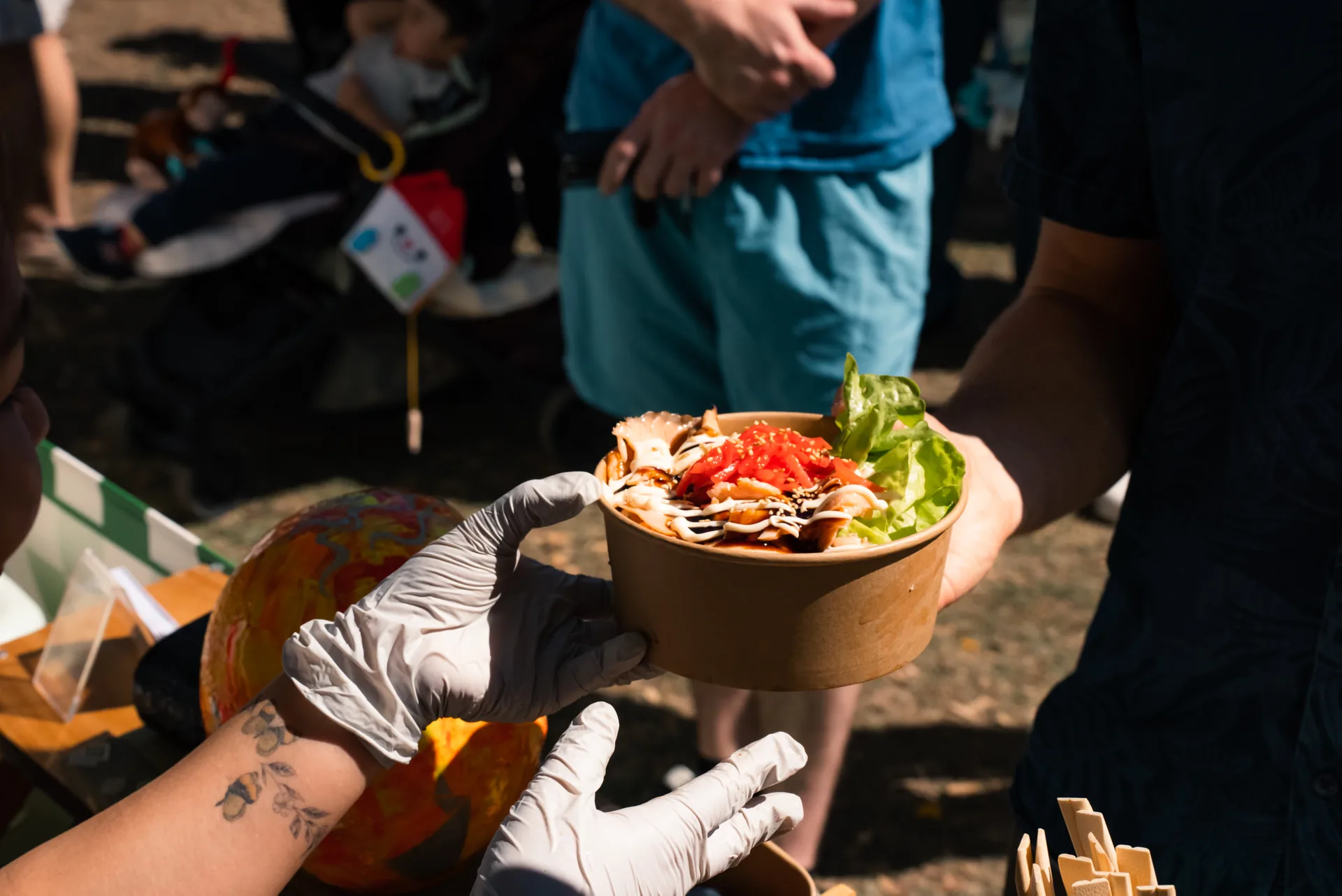 Freshly prepared Oh!NIGIRI rice bowl being handed across the counter