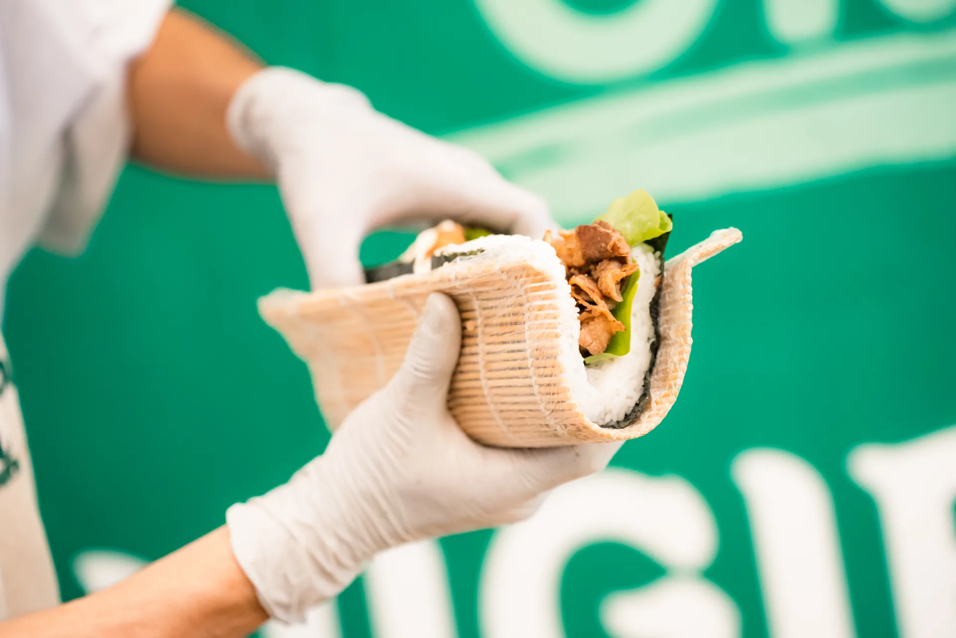 Fresh Oh!NIGIRI rice burger held in a gloved hand