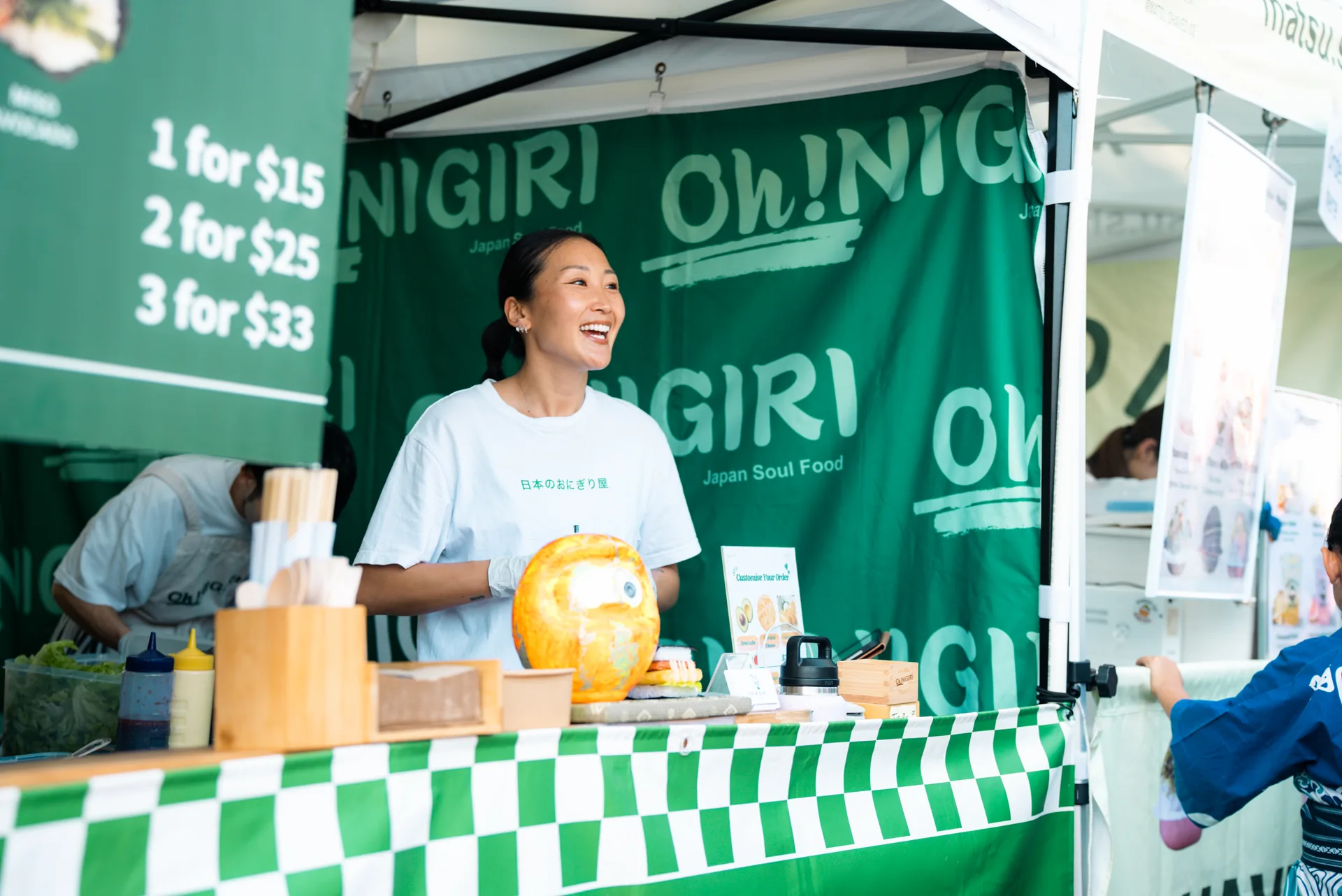 Oh!NIGIRI team member welcoming customers at the market counter