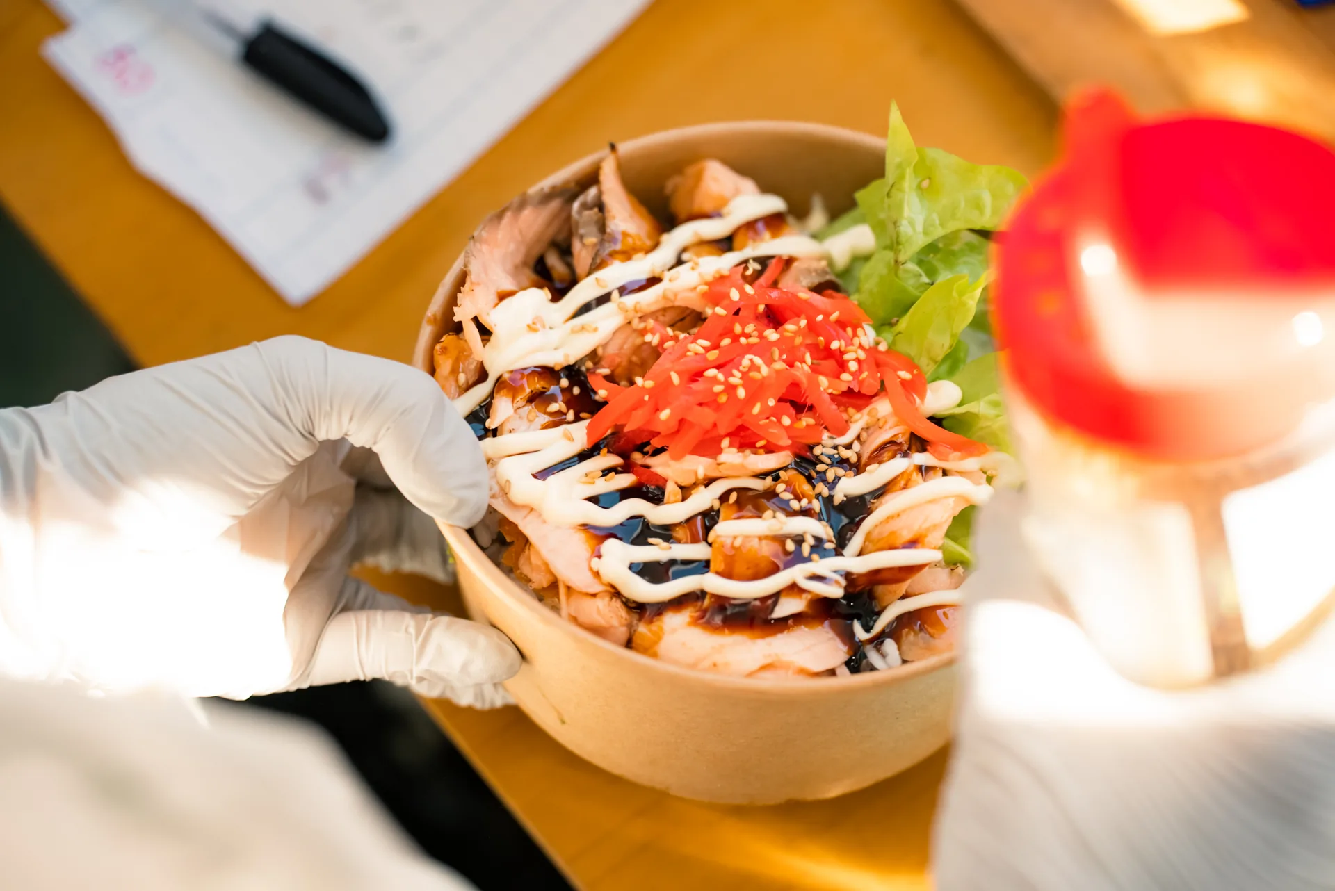 Freshly prepared Oh!NIGIRI rice bowl with meat, salad and sauces